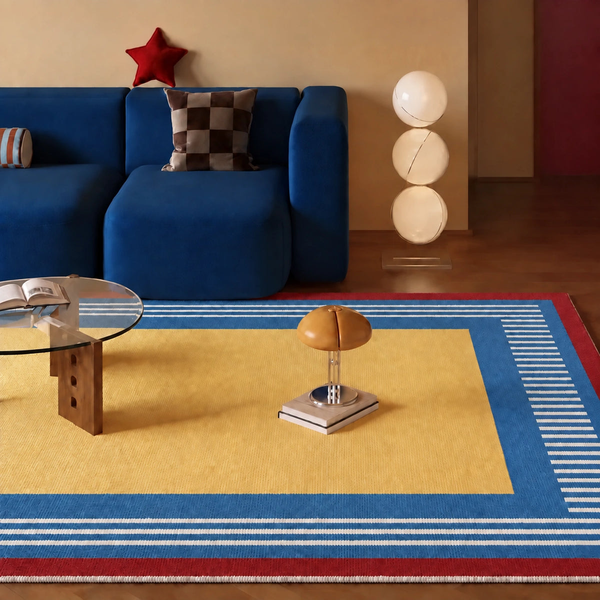 A colorful area rug with a yellow center, blue and white striped borders, and a red outer border, styled in a modern living room setting with a blue sofa and wooden floor.