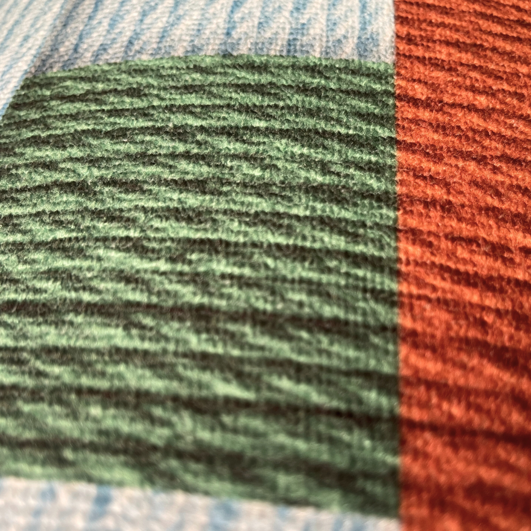 Close-up of green, red, and blue textured fabric swatches.